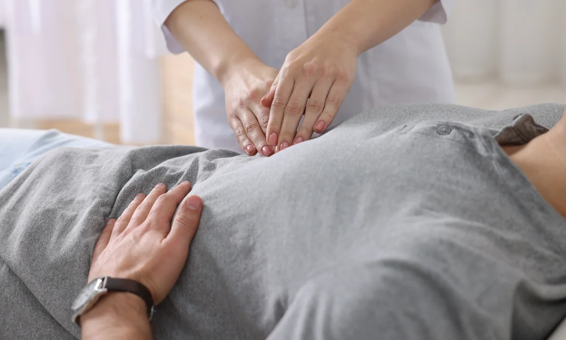 Médico de Sanvite revisando el abdomen de un paciente con antecedentes quirúrgicos complejos.